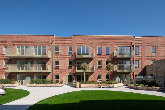 Completed brick apartment buildings and landscaped courtyard at South Oxhey
